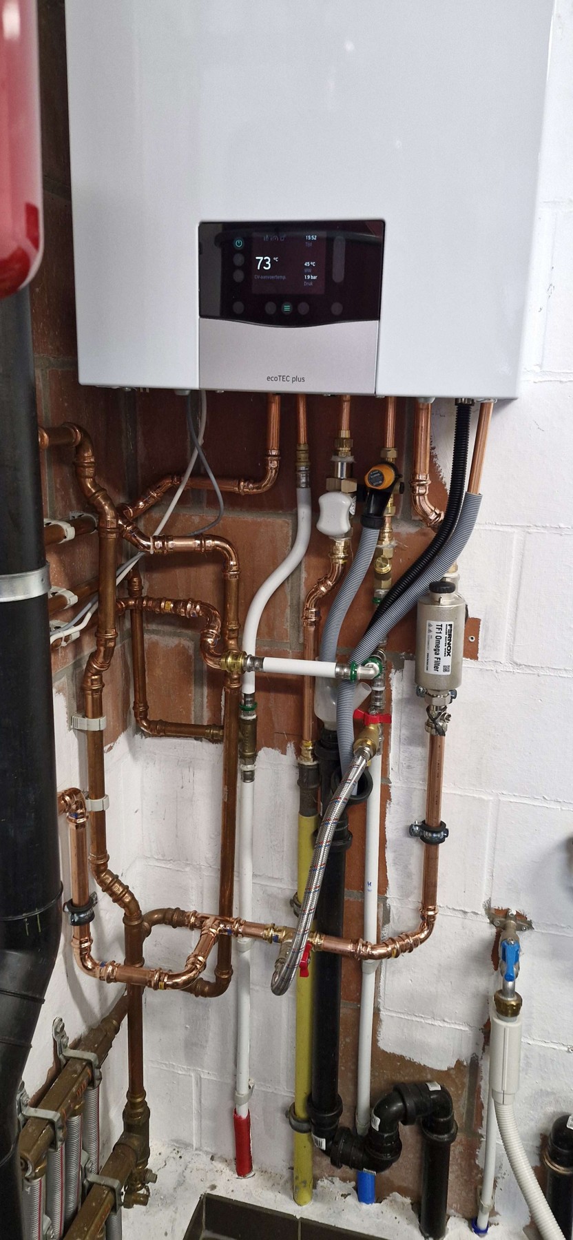 Afgewerkt leidingwerk en filters onder de Vaillant-ketel in Varsenare